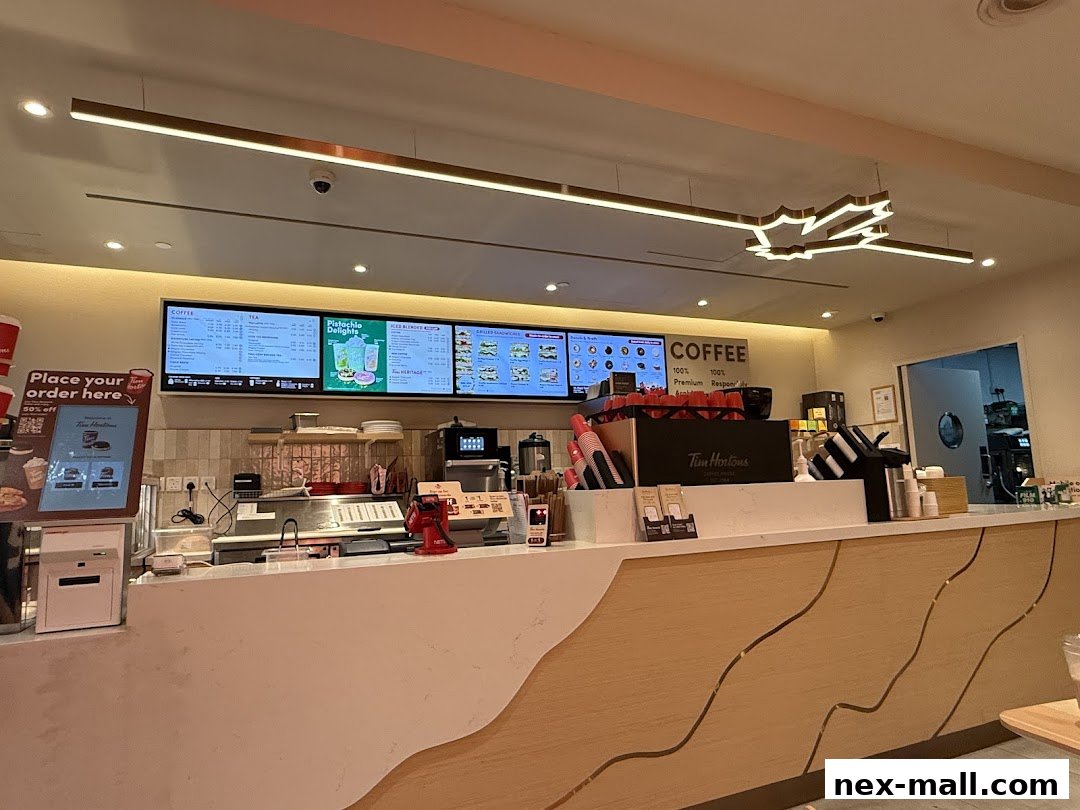 Interior view of a Tim Hortons counter with digital menus displaying coffee, tea, and iced blended drinks.
