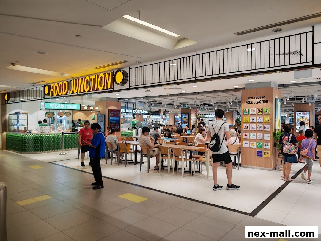 People dining at tables in a bustling food court with a prominent 'Food Junction' sign.