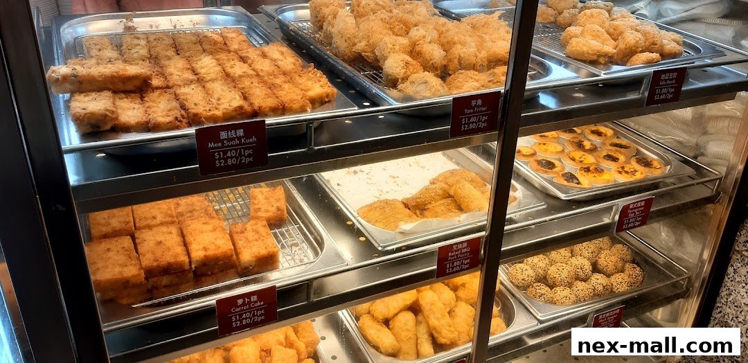 A display case filled with various fried snacks and pastries, including savory cakes and sweet tarts.