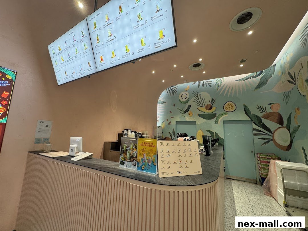 A modern beverage shop counter with digital menus and vibrant tropical wall art.