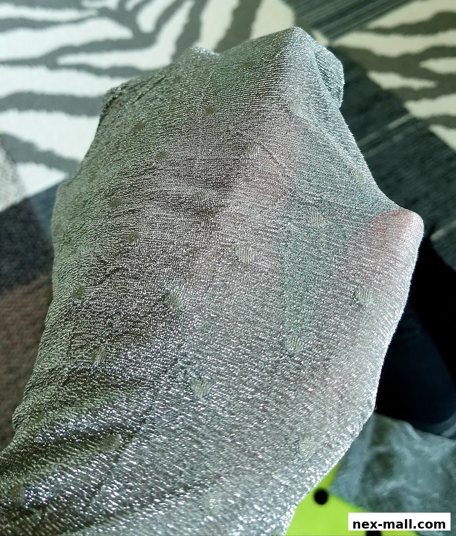 A close-up shot of a hand wearing sheer, silver, polka-dot patterned stockings.