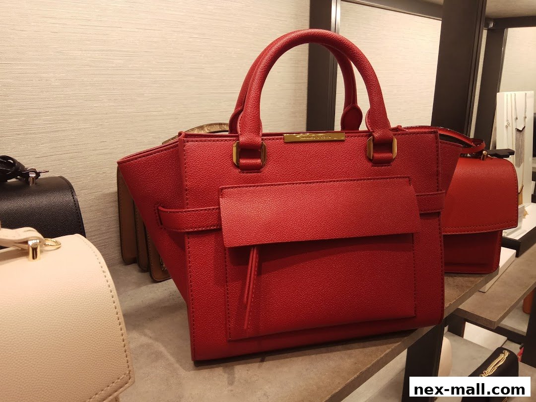 A close-up view of stylish red handbags displayed on shelves in a retail store.