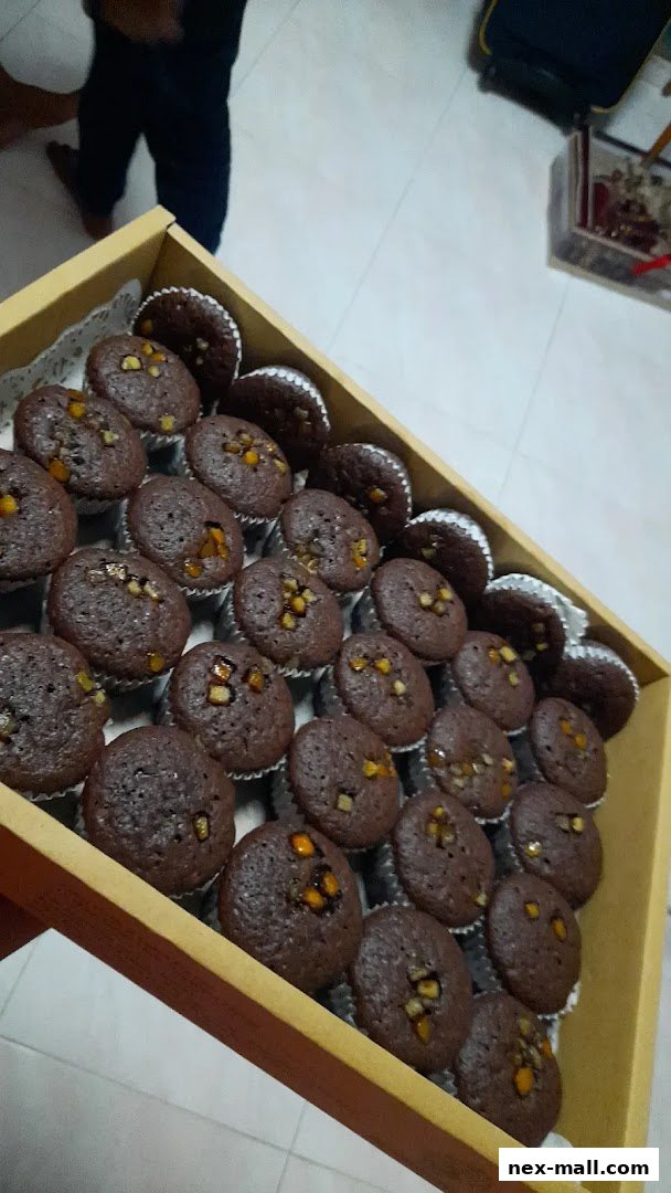 A tray of chocolate cupcakes with candied fruit toppings.