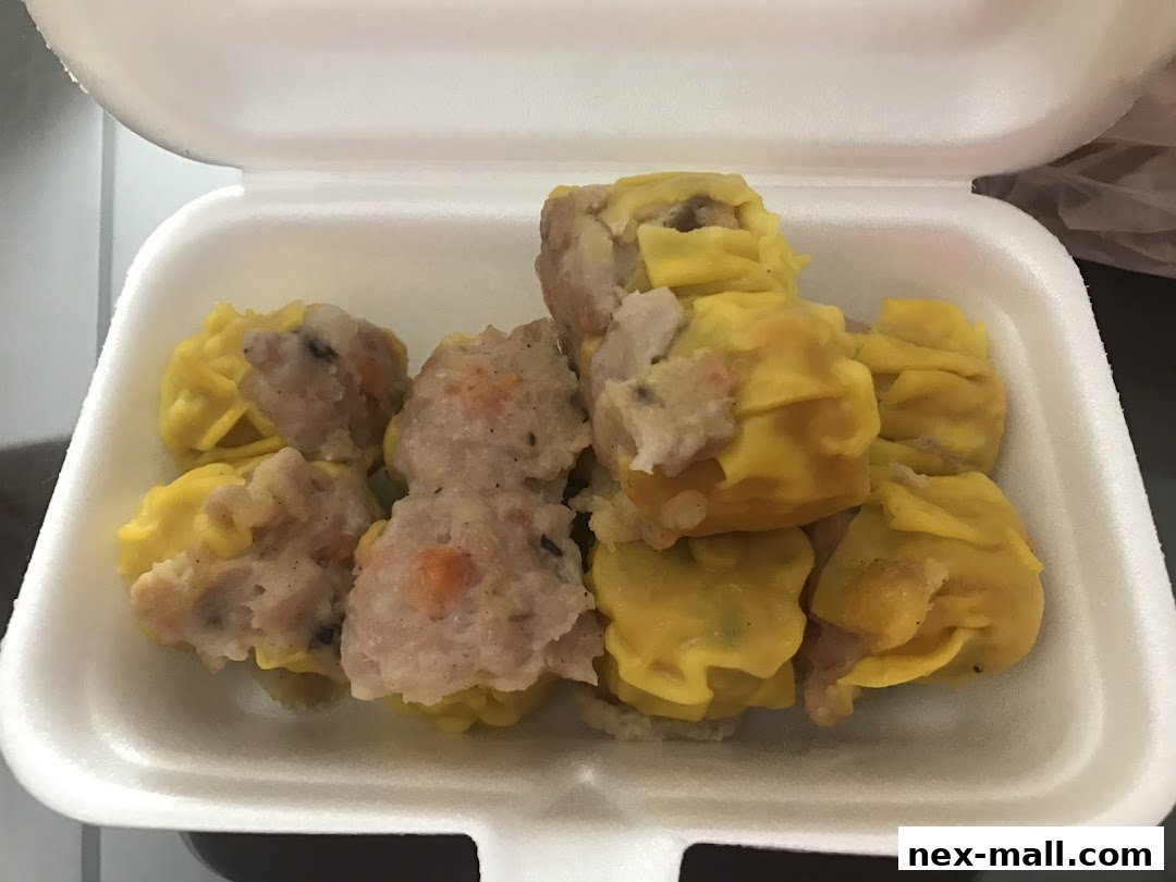 A white takeout container filled with assorted dim sum dumplings.