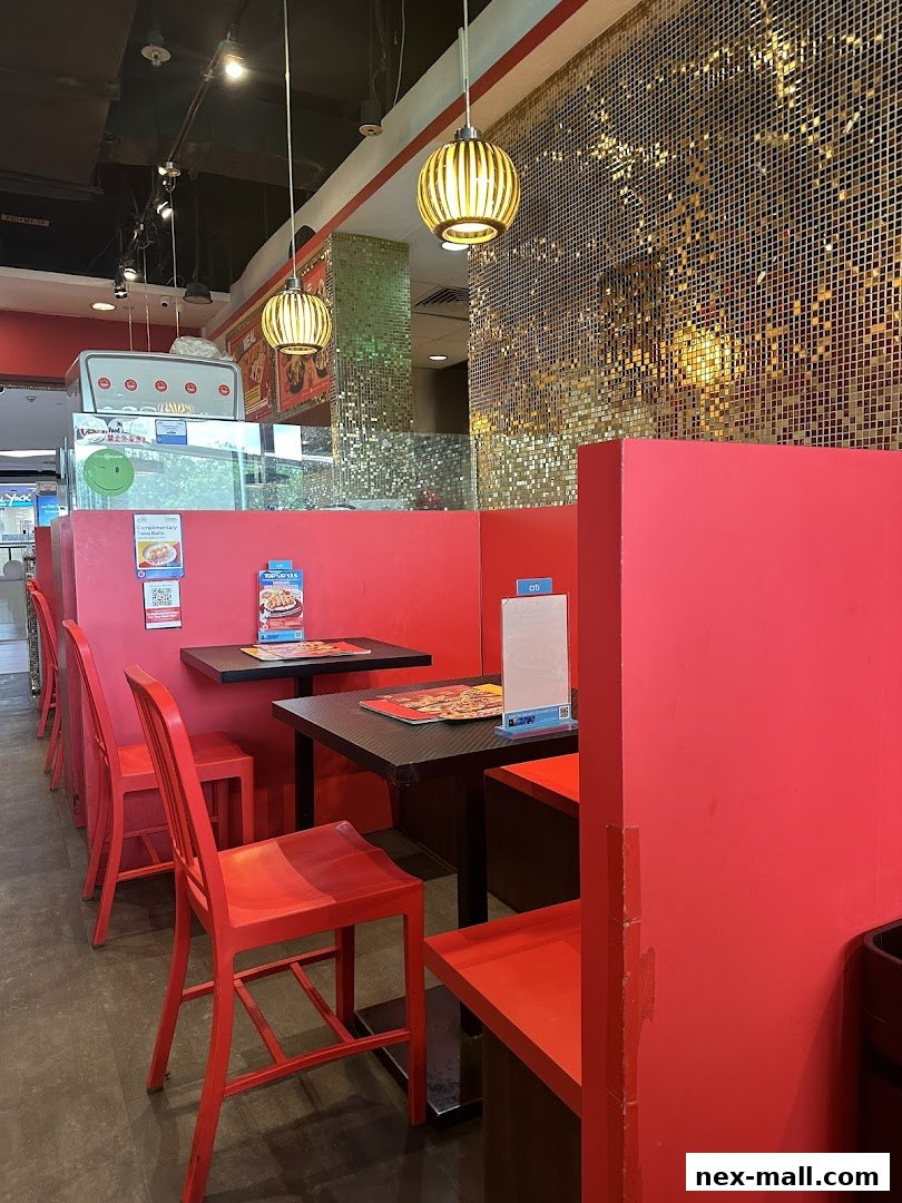 Interior view of Monster Curry with red seating, tables, and a sparkling gold wall.