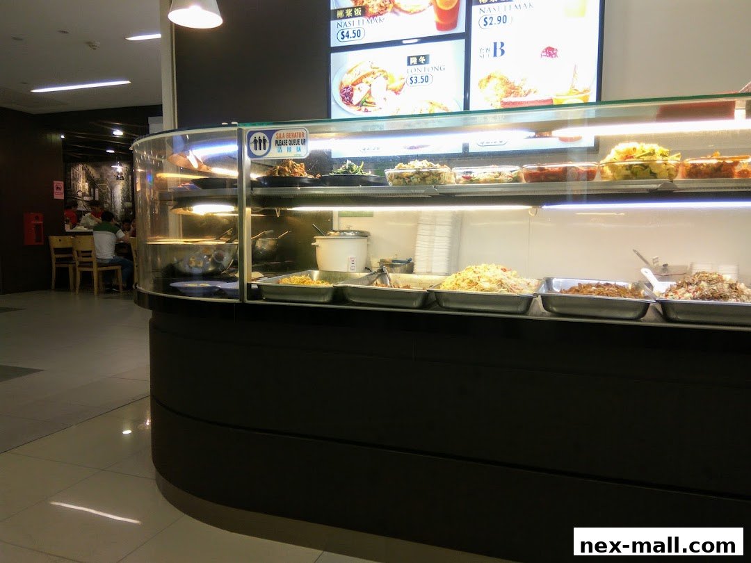 A display counter filled with various food dishes, with a menu board above.