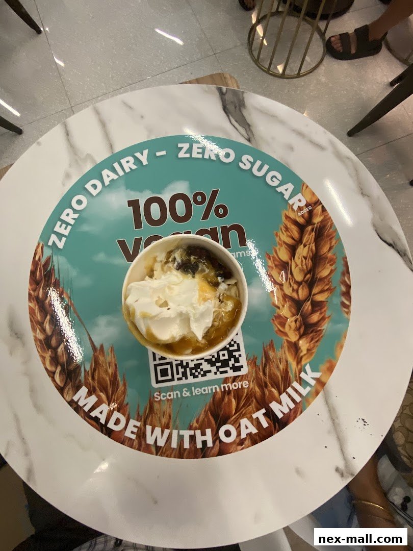 A cup of dessert with whipped cream and sauce sits on a table with a circular graphic.