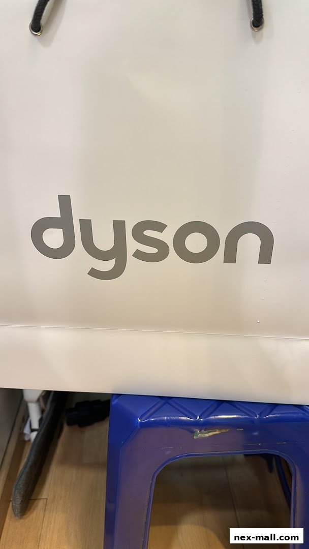 A white shopping bag with the Dyson logo and a blue stool in front of it.
