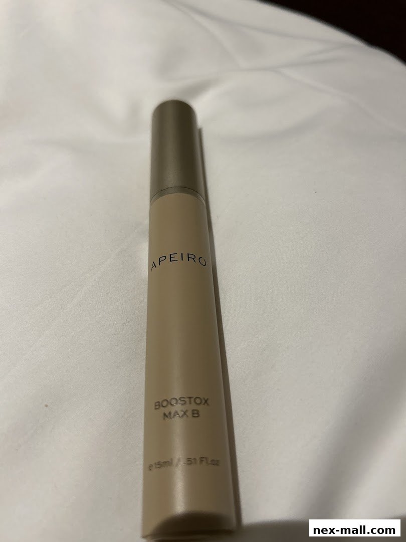 A close-up shot of a beige cosmetic product tube with brand and product name.