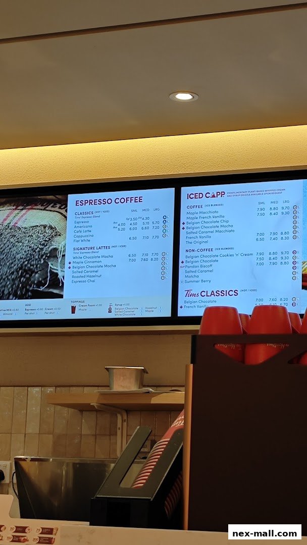 A digital menu board displaying various espresso and iced coffee drinks with prices.