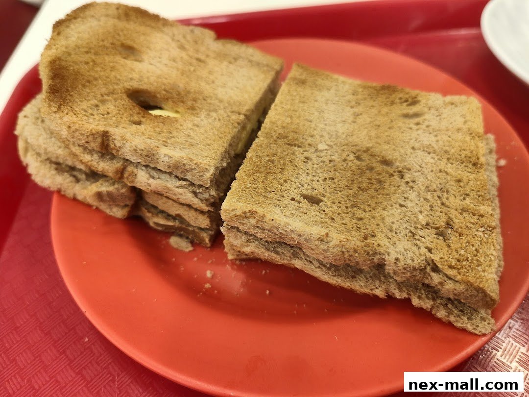 A close-up shot of kaya toast with butter on a red plate.