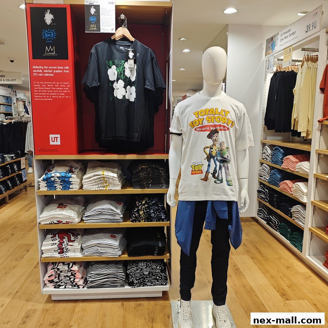 A display of graphic t-shirts and clothing at a Uniqlo store, featuring Toy Story and art collections.
