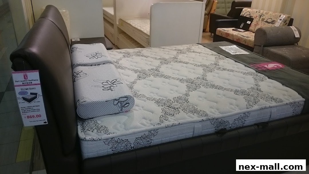 A close-up view of a queen-size bed with a patterned mattress and a dark leather bed frame.