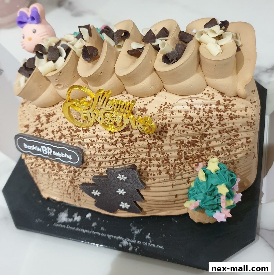 A festive Baskin-Robbins log cake decorated with chocolate frosting and Christmas ornaments.
