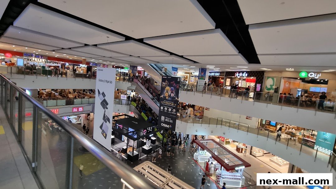 A bustling multi-level shopping mall interior with various shops and escalators.