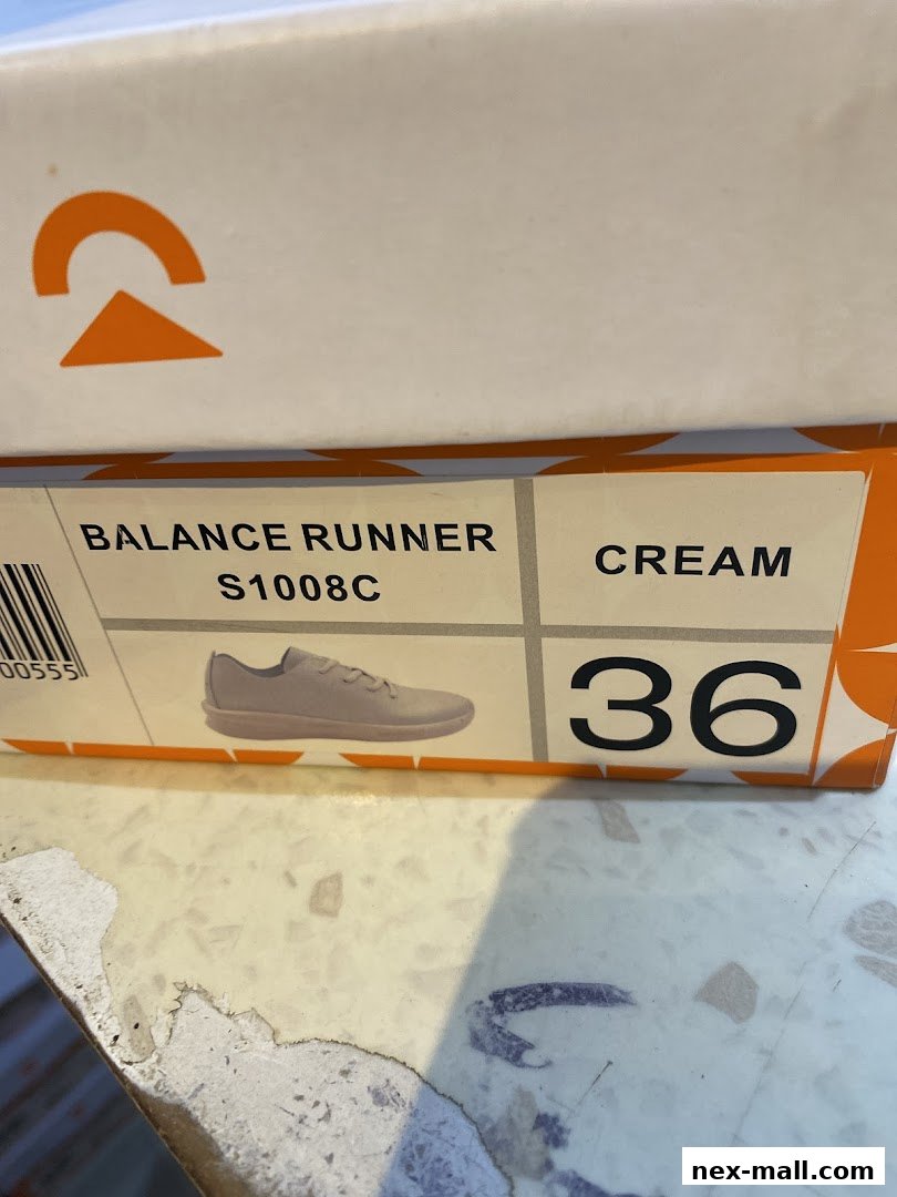 A close-up of a shoe box showing a cream-colored Balance Runner shoe, size 36.