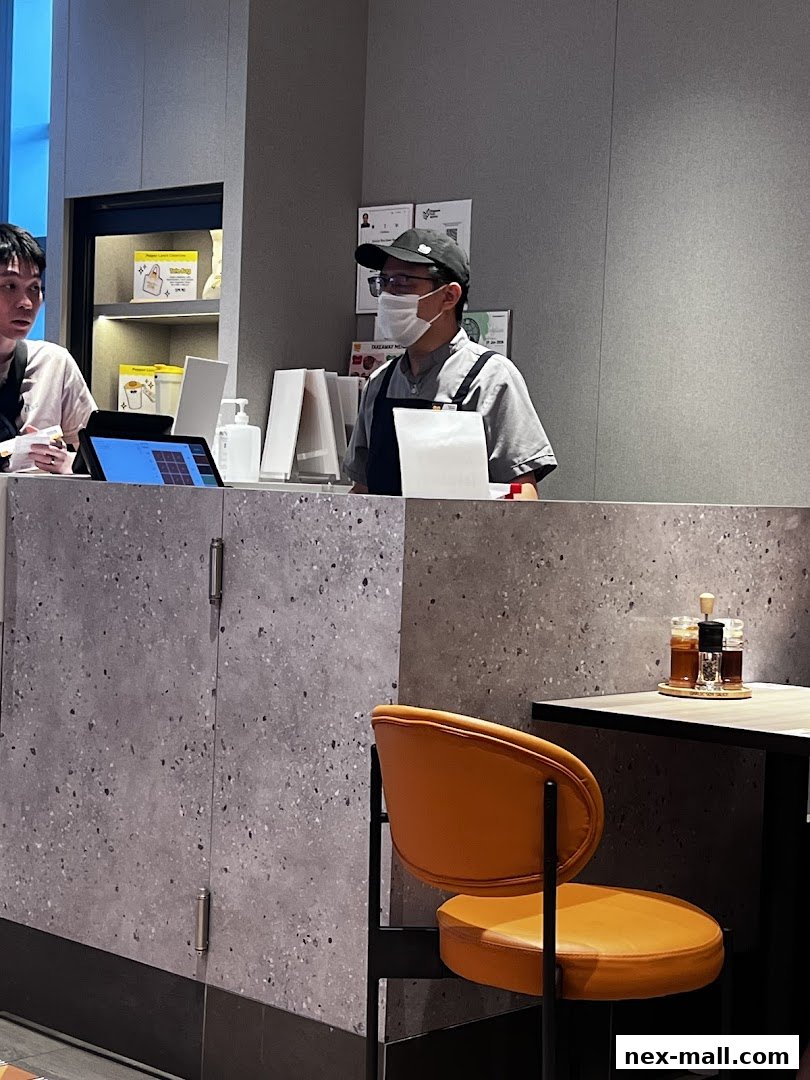 Staff members at the counter of a Pepper Lunch restaurant, with a tablet and condiments visible.