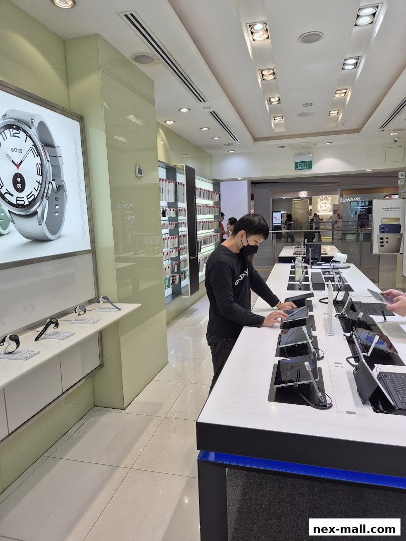 A person interacts with devices at a Samsung Experience Store, showcasing smartwatches and tablets.