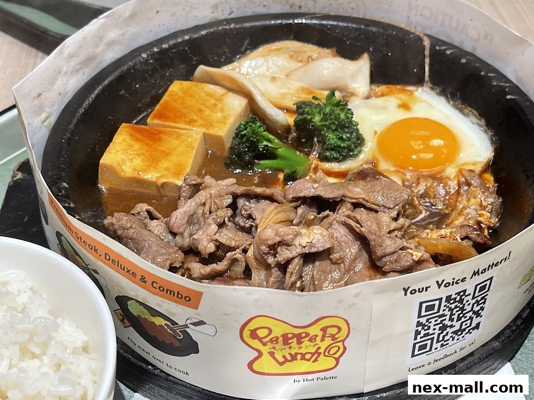 A sizzling hot plate meal with beef, tofu, egg, and broccoli, served with rice.