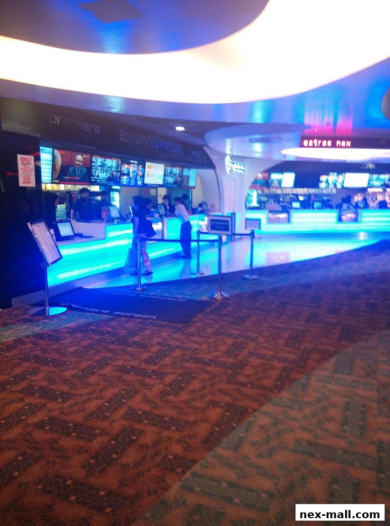 The interior of a cinema lobby with a brightly lit counter for box office and concessions.