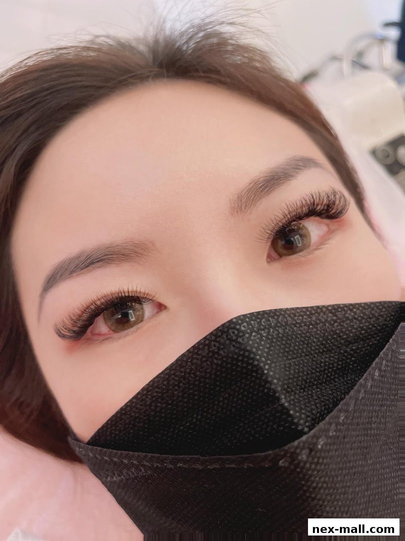 Close-up of a woman's eyes with beautiful eyelash extensions and a black mask.