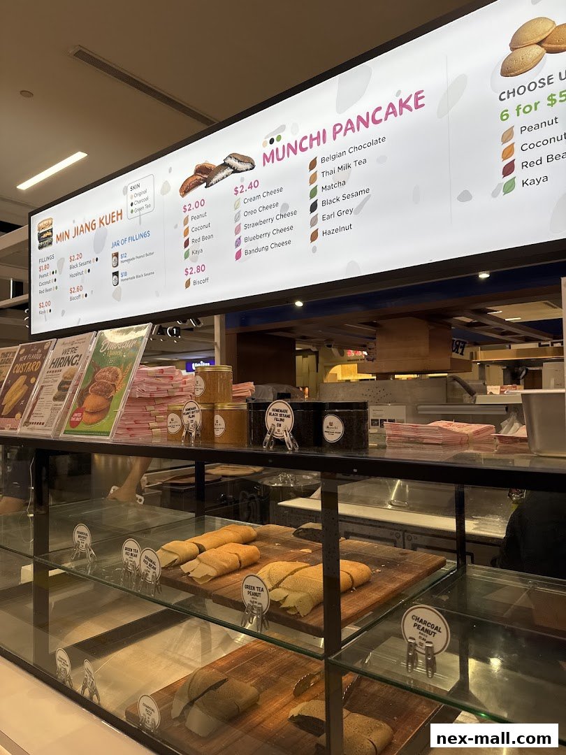 A brightly lit menu board showcasing various pancake fillings and flavors at Munchi Pancakes.
