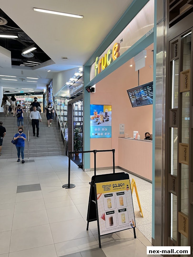 The entrance to Fruce NEX, a beverage shop, with a promotional sign outside.
