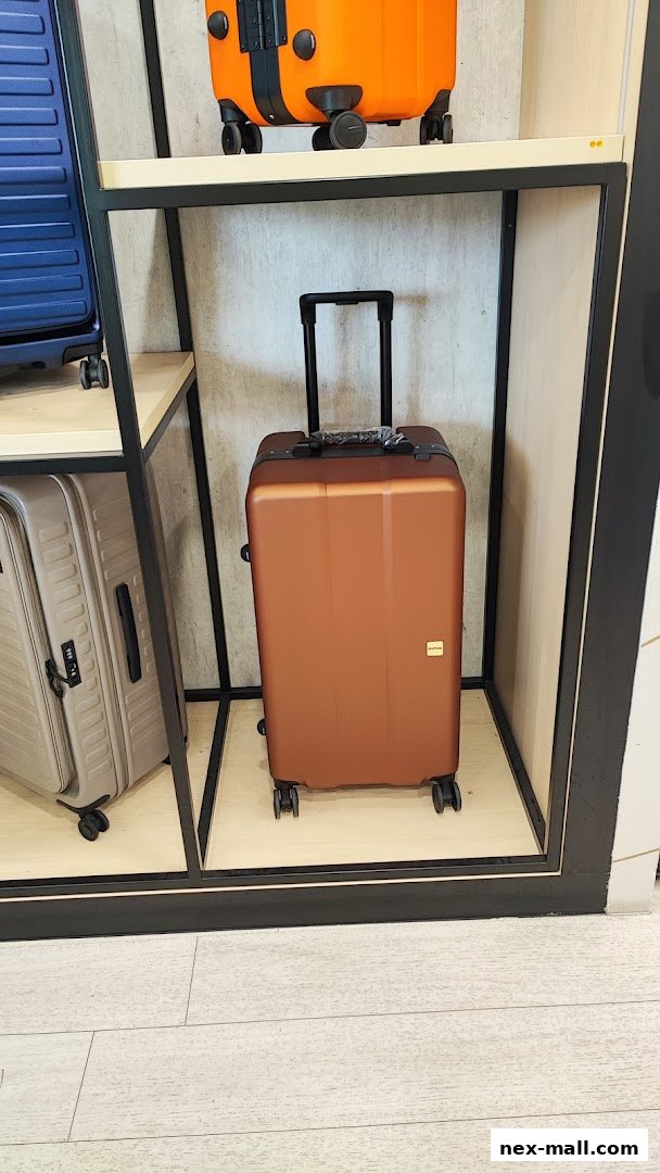 A display of various suitcases, including a prominent bronze suitcase with a retractable handle.