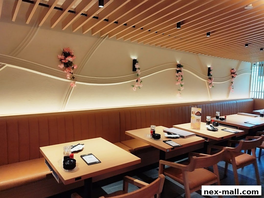 Interior of a Japanese restaurant with tables, seating, and decorative floral accents.