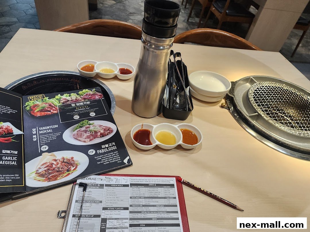 A table setting at a Korean BBQ restaurant with a menu, sauces, and grill.