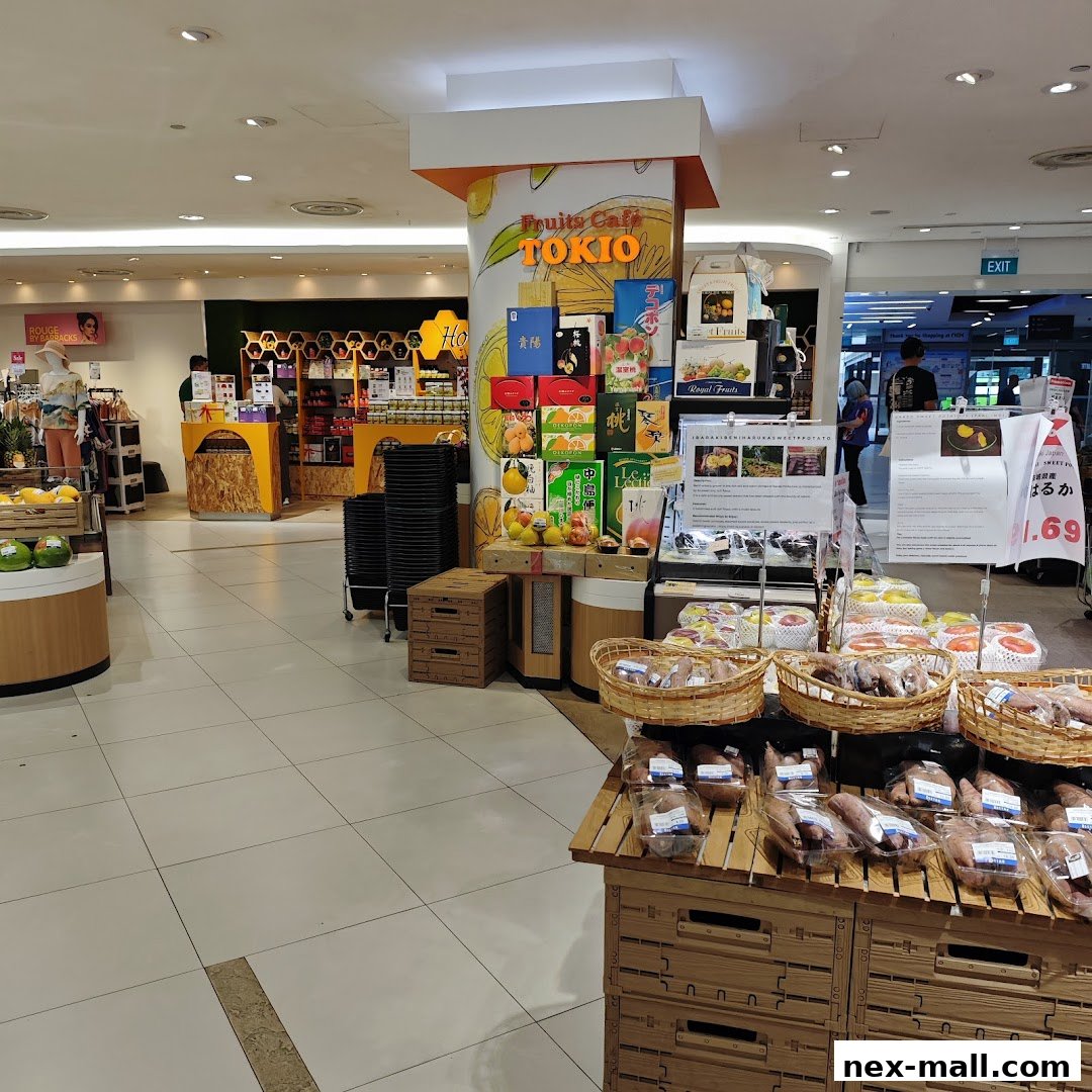 A display of fruits and packaged goods at a store, with a 'Fruits Cafe TOKIO' sign.