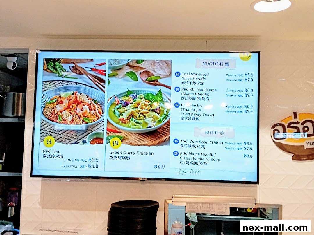 A digital menu board displaying Thai dishes with images and prices.