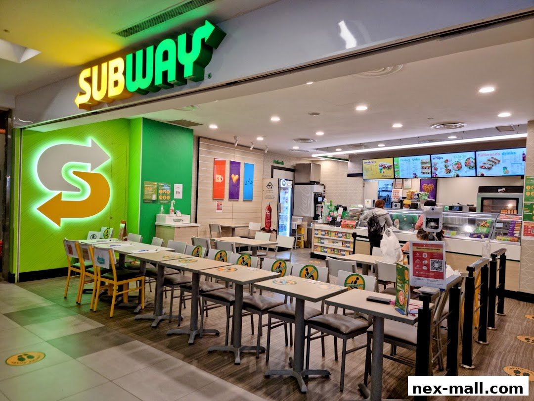 Interior view of a Subway restaurant with seating, counter, and menu boards visible.