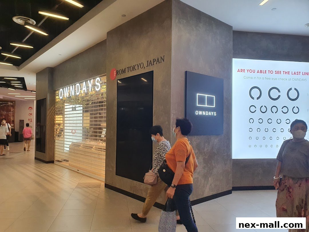 The OWNDAYS shop front with a closed shutter and an eye chart display.