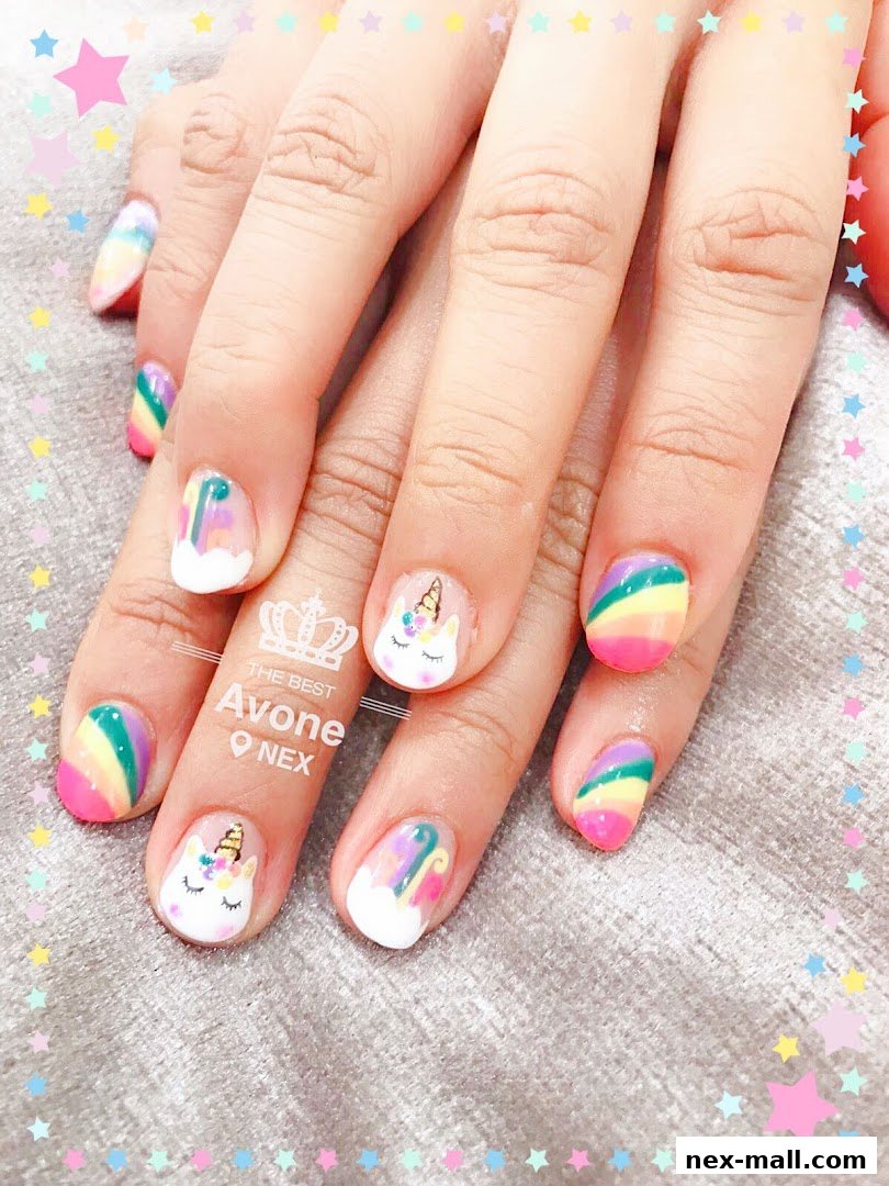 Close-up of hands with colorful unicorn and rainbow themed nail art.
