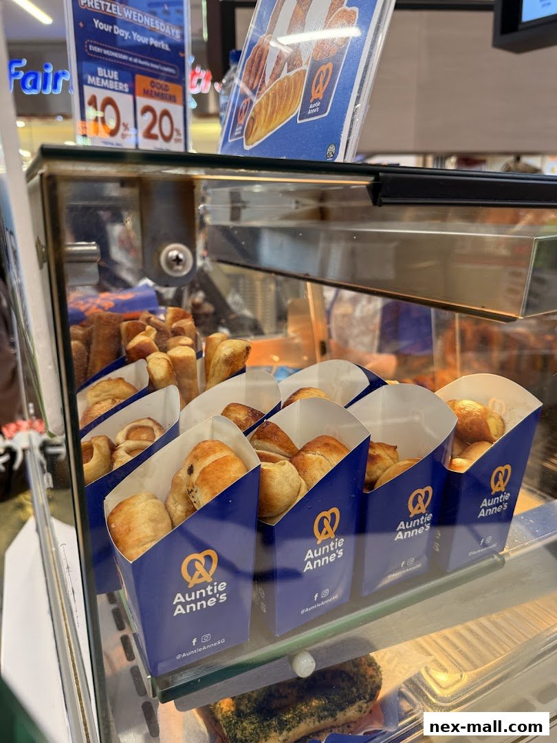 A display case filled with freshly baked Auntie Anne's pretzels in individual paper containers.