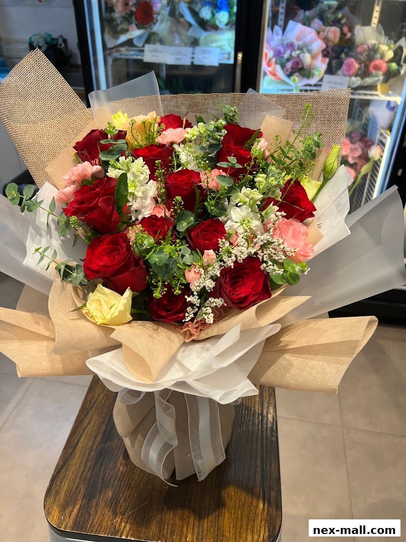 A beautiful bouquet of red roses and other flowers, elegantly wrapped.