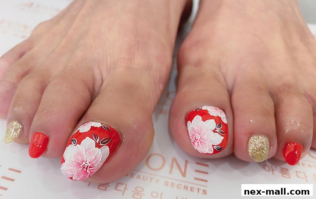 Close-up of feet with intricately painted red and white floral toenails and glitter accents.