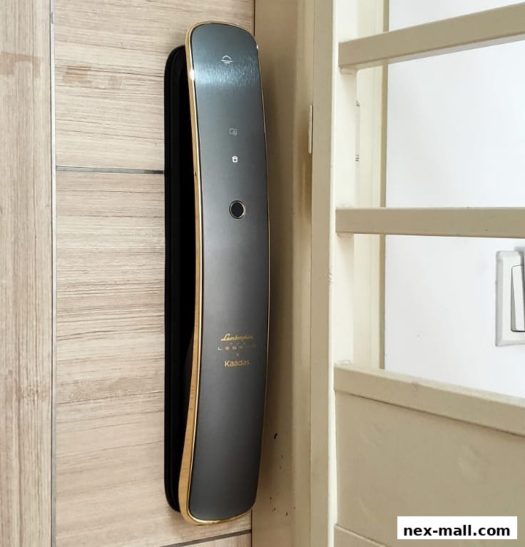 A sleek, modern digital door lock with a gold trim is mounted on a wooden door.