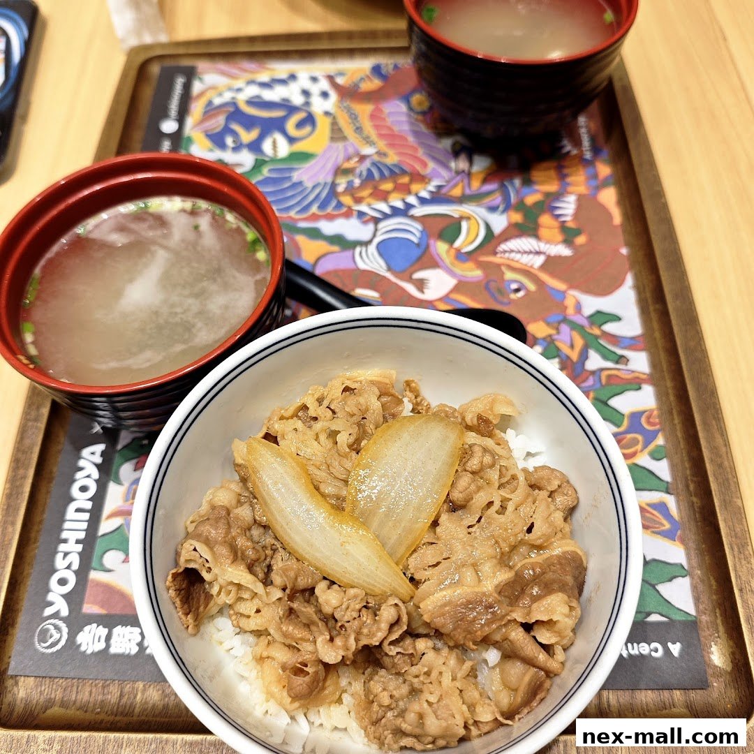 A close-up of a Yoshinoya beef bowl with soup on a decorative tray.