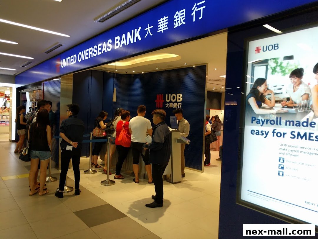 People queuing at the entrance of a United Overseas Bank branch with promotional posters.