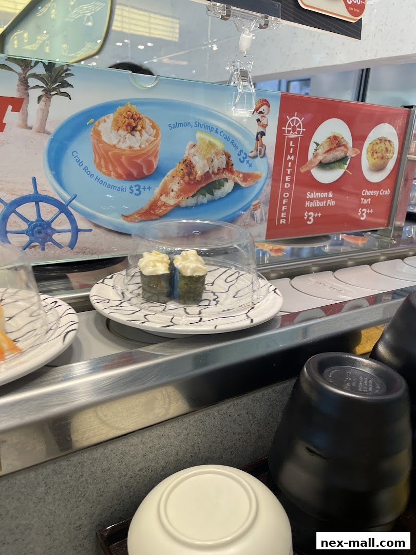 Sushi dishes on a conveyor belt with promotional signs and cups.