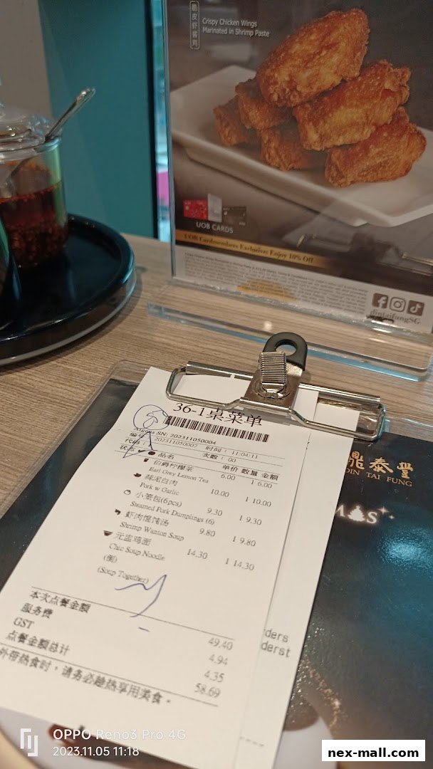 A close-up of a Din Tai Fung receipt and a promotional image of crispy chicken wings.
