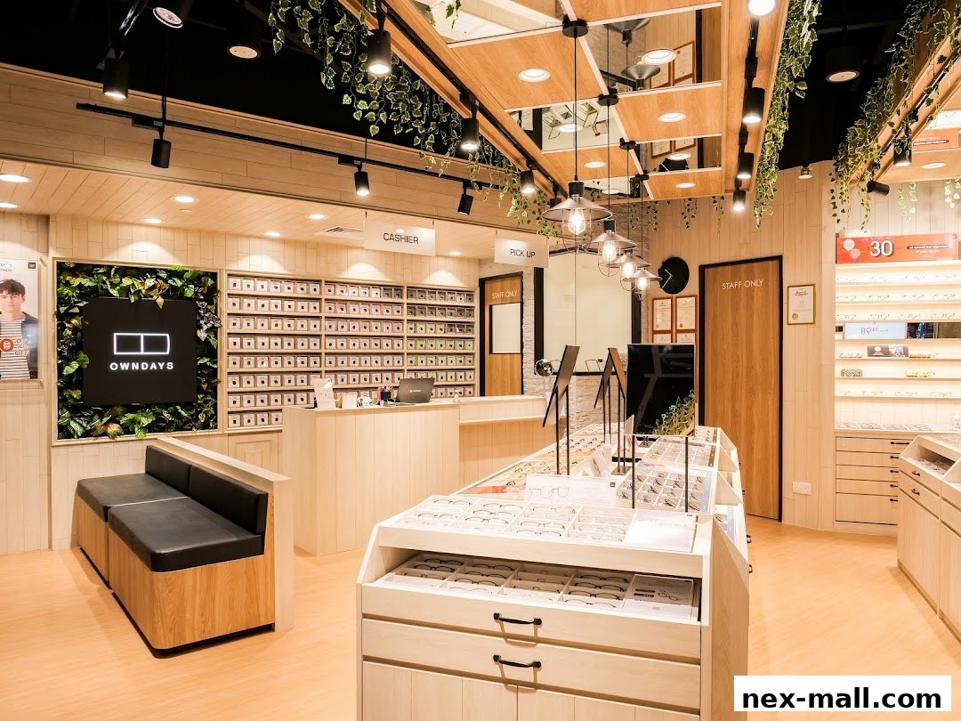 Interior of an OWNDAYS eyeglasses shop with displays of frames and a cashier counter.