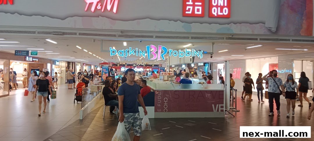 People walking in a mall with shops like H&M, Uniqlo, and Baskin Robbins visible.