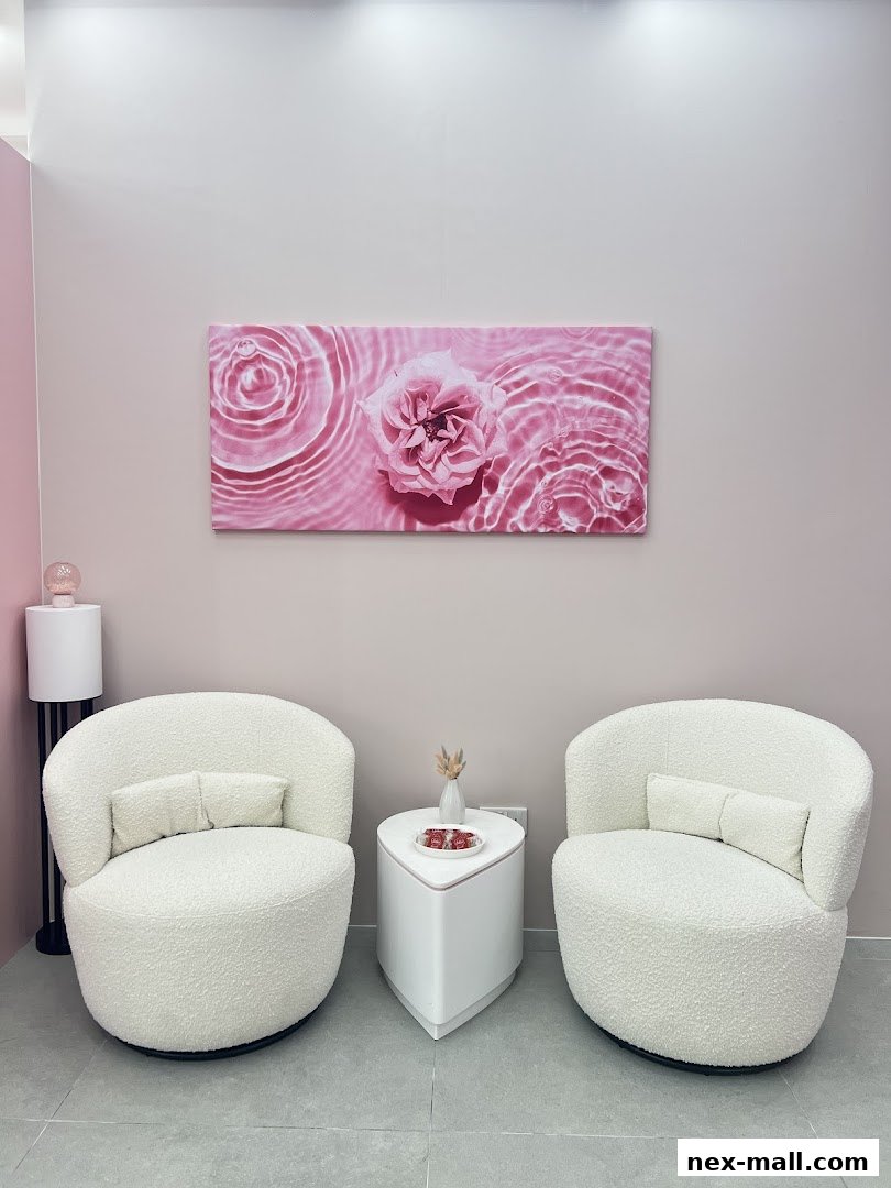 A serene waiting area with plush white chairs, a modern side table, and floral art.