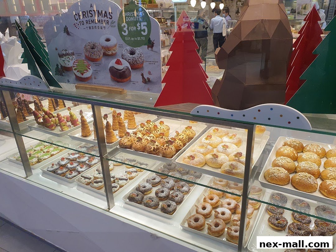 A display case filled with various donuts and pastries, decorated for Christmas.
