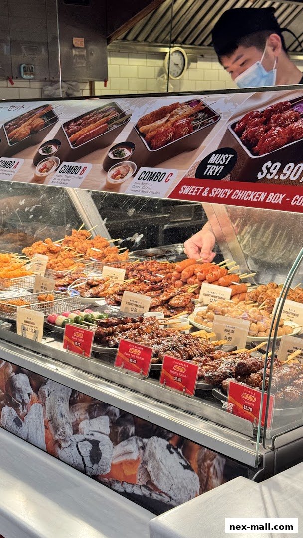 A display of various Japanese skewers and food boxes with prices and descriptions.
