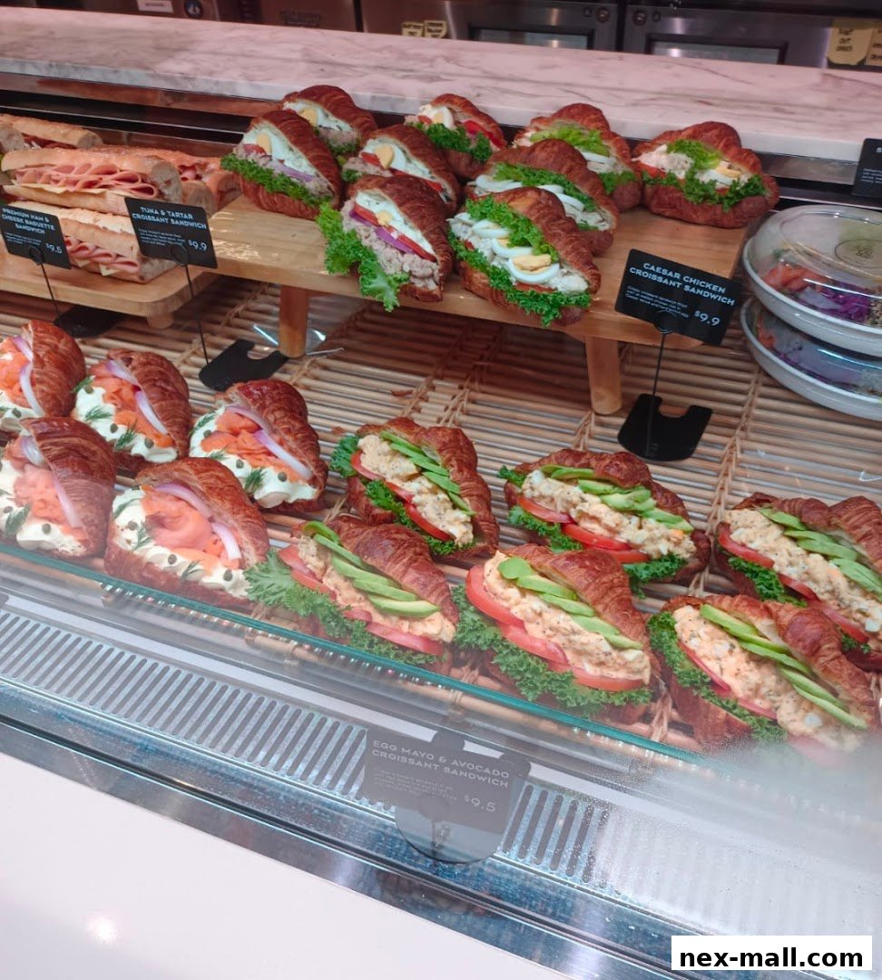 A display case filled with various gourmet croissant sandwiches.