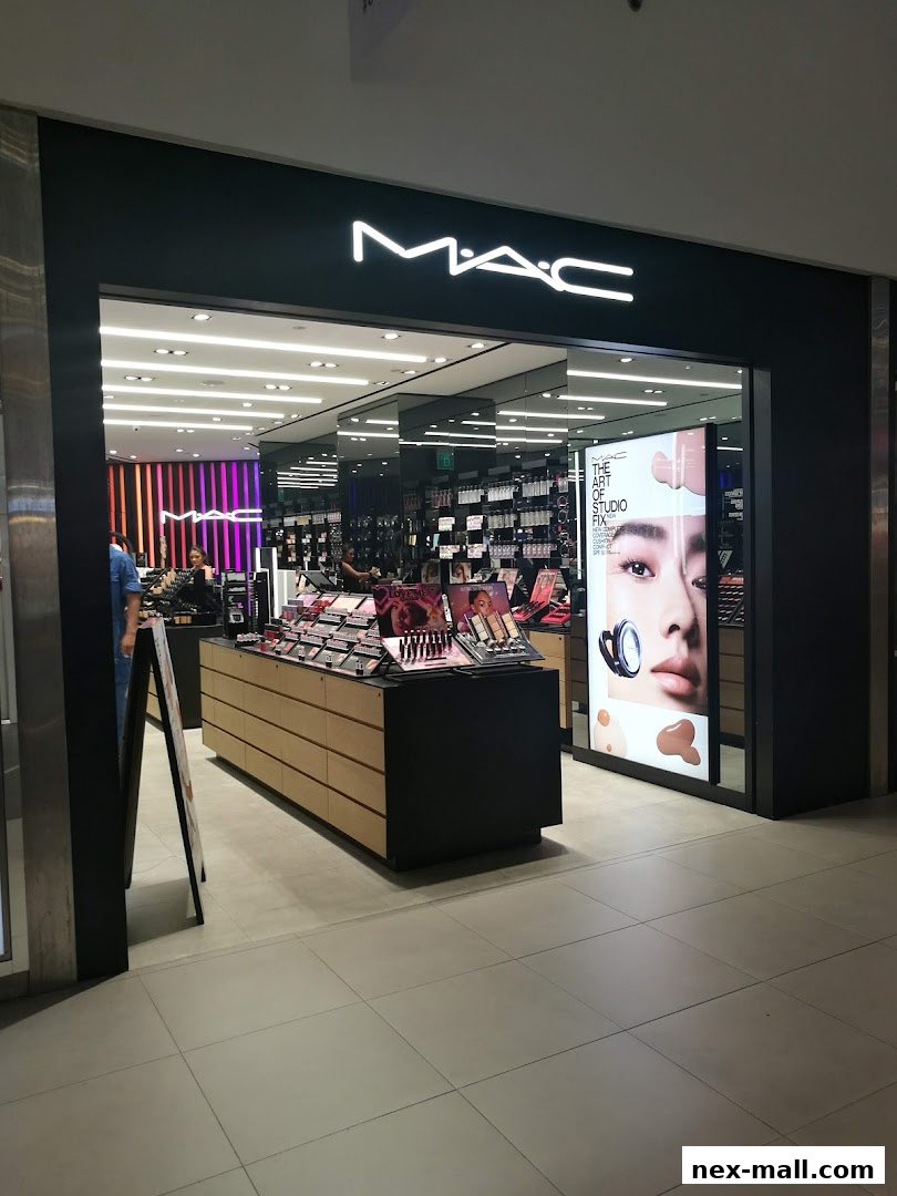 The entrance of a MAC cosmetics store with makeup displays and a large advertisement.